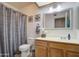 Bathroom with a shower/tub combo, toilet, vanity, and a decorative mirror at 1021 S Greenfield Rd # 1142, Mesa, AZ 85206