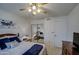 Well-lit bedroom featuring a ceiling fan, bed with blue accents, dresser, and mirrored closet doors at 1021 S Greenfield Rd # 1142, Mesa, AZ 85206