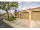 Single-story home with a two-car garage, manicured lawn, and paved driveway leading up to the entrance at 1021 S Greenfield Rd # 1142, Mesa, AZ 85206