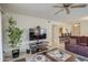 Cozy living room with tile floors, ceiling fan, modern entertainment center and access to the kitchen at 1021 S Greenfield Rd # 1142, Mesa, AZ 85206