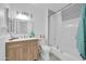 Bright bathroom with a wood vanity, chrome fixtures, and a white subway-tiled shower and tub at 10646 W Tropicana Cir, Sun City, AZ 85351