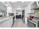 Bright kitchen features stainless steel appliances, modern cabinetry, and views into the adjacent living area at 10646 W Tropicana Cir, Sun City, AZ 85351