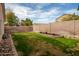 Backyard with green grass, a sturdy block wall, and landscape beds, offering privacy and space at 11330 W Eden Mckenzie Dr, Surprise, AZ 85378