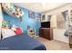 Bedroom with blue walls, carpet, and a window offering natural light and an interesting youthful decor at 11330 W Eden Mckenzie Dr, Surprise, AZ 85378