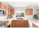 Well-lit kitchen featuring modern appliances, wood cabinetry, and a bright window at 11330 W Eden Mckenzie Dr, Surprise, AZ 85378