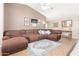 Spacious living room features a vaulted ceiling, cozy brown sofa, and decorative rug at 11330 W Eden Mckenzie Dr, Surprise, AZ 85378