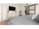 Cozy main bedroom featuring a dresser with a TV, a mirror and access to the ensuite bathroom at 11330 W Eden Mckenzie Dr, Surprise, AZ 85378