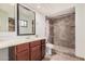 Bathroom with a large mirror, vanity, and a tiled shower with glass doors at 11403 N 57Th Dr, Glendale, AZ 85304