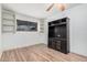 Room featuring built-in shelves, laminate flooring, and a dark entertainment center at 11403 N 57Th Dr, Glendale, AZ 85304