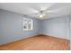 Bright, empty bedroom with new flooring, a ceiling fan, and natural light from the large window at 11431 N 37Th Pl, Phoenix, AZ 85028