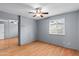 This bedroom features wood floors, a ceiling fan, and a closet with mirrored doors at 11431 N 37Th Pl, Phoenix, AZ 85028