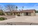 Charming single-story home with desert landscaping, a covered carport and solar panels on the roof at 11431 N 37Th Pl, Phoenix, AZ 85028