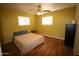 Comfortable bedroom with a ceiling fan, wood-look flooring, and plenty of natural light at 120 N 54Th St, Mesa, AZ 85205