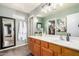 This bathroom has a wooden vanity, a large mirror, and two white robes hanging on the wall at 12162 W Dreyfus Dr, El Mirage, AZ 85335