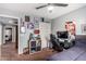 This bedroom has grey-blue walls, tan carpet, and a black gaming chair beside a desk at 12162 W Dreyfus Dr, El Mirage, AZ 85335