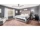 Stylish bedroom with a tufted headboard, ceiling fan, and natural light from the window at 12162 W Dreyfus Dr, El Mirage, AZ 85335