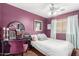 Cozy bedroom with purple walls and a white ceiling fan complemented by a modern desk and art at 12162 W Dreyfus Dr, El Mirage, AZ 85335