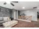 Open loft-style hallway with wood railings, gray walls, and a comfortable gray couch for lounging at 12162 W Dreyfus Dr, El Mirage, AZ 85335