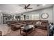 Open-concept living room featuring a large brown sectional, ceiling fan, and adjoined kitchen at 12162 W Dreyfus Dr, El Mirage, AZ 85335