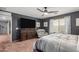 This bedroom features a ceiling fan, a dresser with a TV, and an upholstered chair at 12162 W Dreyfus Dr, El Mirage, AZ 85335