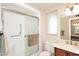 Bright bathroom with a shower, frosted glass door, and white tiled walls at 12418 W Galaxy Dr, Sun City West, AZ 85375