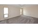 Spacious bedroom with two windows and neutral-colored carpet at 12418 W Galaxy Dr, Sun City West, AZ 85375