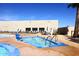 A serene hot tub area by the pool with lounge chairs, a well-maintained building, and beautiful landscaping at 12418 W Galaxy Dr, Sun City West, AZ 85375