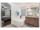 Relaxing bathroom featuring a soaking tub, vanity with a framed mirror, and an entry way to the bedroom at 12530 W Jackson St, Avondale, AZ 85323