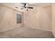 Neutral bedroom with plush carpeting, ceiling fan, and plenty of natural light from the large window at 12530 W Jackson St, Avondale, AZ 85323