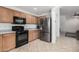 Bright kitchen with stainless steel fridge, black range, and neutral tile flooring at 12530 W Jackson St, Avondale, AZ 85323