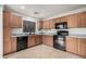 Well-lit kitchen featuring wood cabinets, black appliances, and neutral tile flooring at 12530 W Jackson St, Avondale, AZ 85323