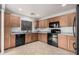 Well-lit kitchen featuring wood cabinets, black appliances, and neutral tile flooring at 12530 W Jackson St, Avondale, AZ 85323