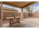 Covered patio area with a wooden table, perfect for outdoor dining and relaxation at 12530 W Jackson St, Avondale, AZ 85323