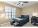 Inviting bedroom with a dark-colored bed, window with blinds, and functional desk space at 13432 N 154Th Ln, Surprise, AZ 85379