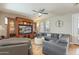 Cozy living room featuring a large sectional, wood-look floors, ceiling fan, and built-in entertainment center at 13432 N 154Th Ln, Surprise, AZ 85379