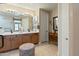 Bright main bathroom with double sinks, vanity lighting, and wood cabinetry with tile flooring at 13432 N 154Th Ln, Surprise, AZ 85379