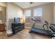 Bright workout area showcasing a treadmill, TV, and ample natural light at 13432 N 154Th Ln, Surprise, AZ 85379