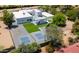 Aerial view of home featuring tennis court, pool, patio, putting green, and manicured landscaping at 13613 N 76Th St, Scottsdale, AZ 85260