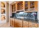 Elegant bar area with custom cabinetry, granite countertops, and a wine rack at 15241 E Pageland Cir, Fountain Hills, AZ 85268