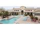 Aerial view of a community pool and clubhouse with lounge seating and lush landscaping at 16013 S Desert Foothills Pkwy # 2082, Phoenix, AZ 85048