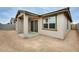 Back patio with sliding glass door to house and window, patio is in a dirt filled backyard at 16036 W Desert Hollow Dr, Surprise, AZ 85387