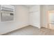 This bedroom features neutral carpet, a window for natural light, a closet, and access to another room at 16036 W Desert Hollow Dr, Surprise, AZ 85387