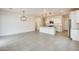 Bright, open living room with modern lighting, tile flooring, and a view into the spacious kitchen at 16036 W Desert Hollow Dr, Surprise, AZ 85387