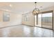 Open living space with neutral tile, large sliding glass doors, modern light fixture, and lots of natural light at 16036 W Desert Hollow Dr, Surprise, AZ 85387