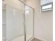 Glass enclosed shower with a built-in shower caddy and bright window at 16036 W Desert Hollow Dr, Surprise, AZ 85387