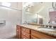 Double vanity bathroom featuring granite countertop, modern lighting, and glass-enclosed shower for a spa-like experience at 16172 W Starlight Dr, Surprise, AZ 85374