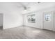 Bright living room with wood-look tile, ceiling fan, white walls and a decorative front door at 1640 W Charleston Ave, Phoenix, AZ 85023