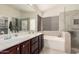 Bathroom featuring dual sinks, walk-in shower and soaker tub at 16811 S 11Th Way, Phoenix, AZ 85048