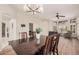 Open-concept dining room flows into the living area featuring wood-look floors and modern lighting at 16811 S 11Th Way, Phoenix, AZ 85048