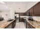 Modern kitchen featuring dark wood cabinetry, stainless appliances, and granite countertops at 16811 S 11Th Way, Phoenix, AZ 85048